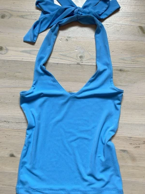 Halterneck topp från BikBok - Väldigt fin blå halternecktopp som jag köpt på Bikbok. Materialet är super (luftigt, tunt, ordentligt, strechtigt) och sitter smickrande på. Är använd fåtal gånger, kanske fem. Verkligen så fin och kan bara se framför mig hur den passar till allt. 