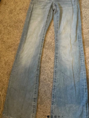 Ljusblå lågmidjade bootcut jeans från Gina Tricot - Säljer ett par ljusblå bootcut jeans från Gina. De har en snygg utsvängd passform nertill. Jättefina jeans!