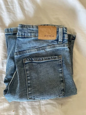 Ljusblå jeans från BK Denim Lab - Snygga ljusblå jeans från BK Denim Lab med klassisk femficksmodell och raka ben. Jeansen har en läderpatch med logga bak i midjan och är gjorda i mjuk denim. Perfekta för en avslappnad och trendig look.