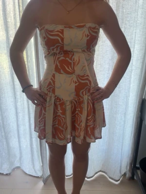 Strapless blommig kortklänning - Säljer en söt axelbandslös kortklänning från peppermayo, så fin och perfekt till sommaren❤️ skriv om du har frågor eller vill diskutera pris. Man kan knyta där bak så den passar olika storlekar. Nypris 500