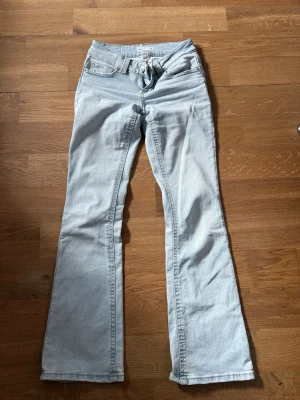 Ljusblå bootcut jeans från Perfect Jeans (lågmidjade) - Säljer ett par ljusblå bootcut jeans från Perfect Jeans. Jeansen har klassisk femficksmodell, normal midja och utsvängda ben. Tillverkade i mjuk denim med snygg tvätt och detaljerade sömmar. Perfekta för en avslappnad och trendig look.
