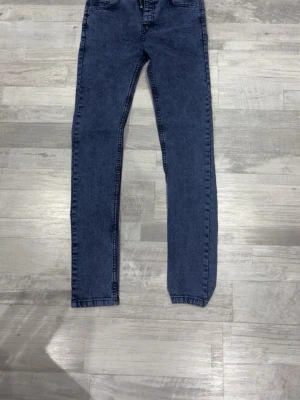 Blå slim fit jeans från Burberry - Snygga blå slim fit jeans från Burberry London England. Jeansen har klassisk femficksdesign och raka ben. Tillverkade i ett mjukt denimtyg som ger en bekväm känsla och stilren look. Perfekta för dig som gillar exklusiva märken och tidlös design.