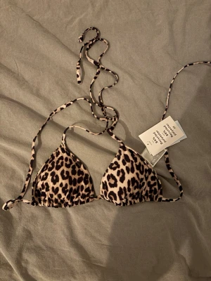 Leopardmönstrad bikiniöverdel H&M - Säljer en superfin leopardmönstrad bikiniöverdel från H&M med snörning och trekantsform. Säljer pga att den inte passade mig, aldrig använd och med prislapp kvar. 💗