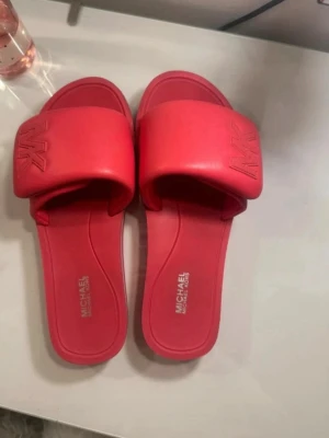 Röda slides från Michael Kors - Snygga röda tofflor från Michael Kors, få gånger använda fint skick💗
