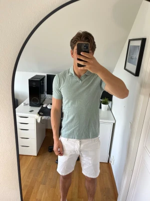 Ljusgrön piké från Bläck - Snygg ljusgrön piké med klassisk krage och korta ärmar. Tillverkad i mjuk bomull. Piken är från Bläck. Hör gärna av dig vid frågor!