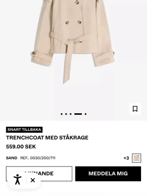 trenchcoat Bershka - Trendig kort trenchcoat i sandfärgat tyg med dubbelknäppning, ståkrage och knytskärp i midjan. Jackan har snygga detaljer som knappar på ärmsluten och markerad axel. Perfekt för en cool och stilren look.