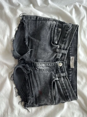 Svarta jeansshorts med låg midja 💋 - Snygga jeansshorts med låg midja och slitningar. Midjemått 34cm och grenhöjd 17cm❣️har en liten fläck på framsidan på första bilden.