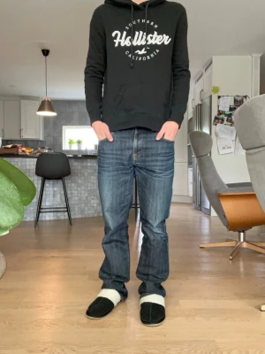 Svart hoodie från Hollister - Svart hoodie från Hollister med vit logga. Riktigt snygg hoodie som är perfekt för de som vill vara lite mer Archive. Storlek S. Hör av dig vid fråga 👍