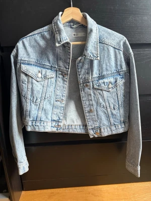Ljusblå jeansjacka från g perfect jeans - Snygg ljusblå jeansjacka från g perfect jeans i croppad modell. Klassisk design med två bröstfickor med lock och knappar, samt knappar framtill. Perfekt för att lyfta vilken outfit som helst.