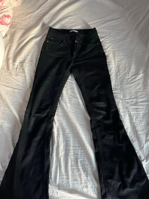 Svarta Jeans - Säljer ett par svarta lågmidjade jeans ifrån Gina Tricot. Använt väldigt mycket innan de blev för korta för mig. Jag är 168 och nu sitter de precis vid fötterna ungefär. Köpte för 500 i butik.