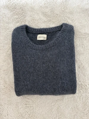 Mörkgrå/blå stickad tröja från American Vintage - Mysig mörkgrå stickad tröja från American Vintage med rund halsringning och långa ärmar. Det är en L men är mer som en M.