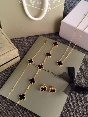 Smyckesset med svarta fyrklöver - Exklusivt smyckesset med halsband, armband och örhängen i guldton. Alla delar har svarta fyrklöverformade hängen med guldfärgad kant. Perfekt för dig som gillar lyxiga och trendiga accessoarer. Tillkommer inte boxen och förpackningen men finns även en ring som inte är med på bilden.
