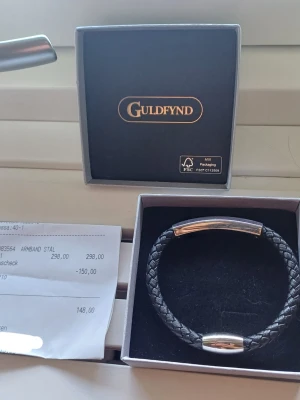 Svart flätat armband från Guldfynd - Snyggt svart armband från Guldfynd med flätad design och detaljer i blankt stål. Inget täcken på användning 