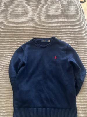 Mörkblå stickad tröja Polo Ralph Lauren - Mörkblå stickad tröja från Polo Ralph Lauren. Nypris runt 2000kr. Använd sparsamt i mycket fint skick inga defekter alls. Storlek S- Passar 170 till 175 beroende på passform