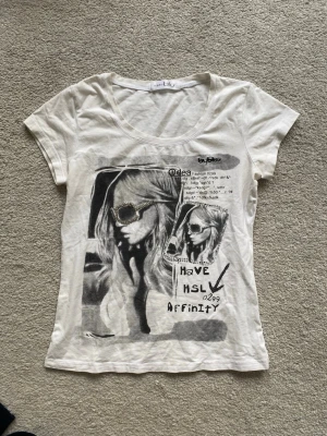 Vit unik T-shirt  - Trendig vit t-shirt köpt secondhand i Spanien och därmed blir extra unik. T-shirten har rund halsringning och korta ärmar. Perfekt för en avslappnad och stilsäker look.