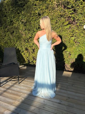 Balklänning  - HELT NY! Så fin ljusblå fest eller balklänning med prislapp på! Vid enda sidan har den justerbar korset men två långa band man drar åt klänningen med. Banden stoppar man in i klänningen💙Köpt på Zalando för 1300kr