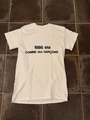 Commes des garcons t shirt  - Riktigt fet och eftertraktad t-shirt med commes des garcons loggan i storlek S. Väldigt bra skick!  Obs: Jag är lite osäker på äktheten då lappen i nacken saknas, därför säljs den billigare (499 kr, nypris ca 3000 kr).  längd cirka 65cm, bredd cirka 44cm. Tveka inte att höra av dig vid frågor eller funderingar!