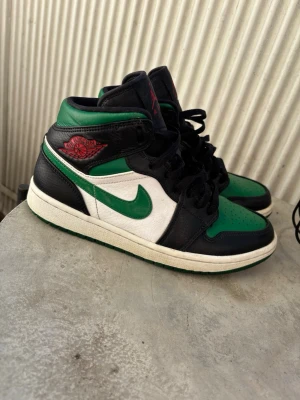 Air Jordan 1 Mid svart/grön/vit - Snygga Air Jordan 1 Mid sneakers i svart, grön o vit. Nästintill aldrig använda! Stl 40