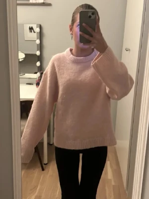 Ljusrosa stickad tröja Gina Tricot - Mysig ljusrosa stickad tröja från Gina Tricot med rund halsringning och ribbade muddar. Tröjan har en avslappnad passform och är perfekt för att hålla sig varm under kyliga dagar. Enkel och stilren design som passar till det mesta.