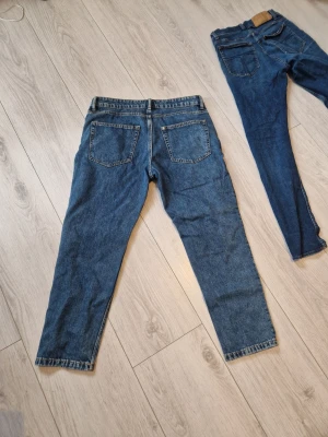 Tiger of sweden jeans plus ett till på köpet  - Här får du 2 för 1. Det mörkare paret är av märket tiger of sweden Jeans och de ljusare som medföljer är av märket &Denim och modellen är Regular Tapered Cropped. Storlek 32 x 32