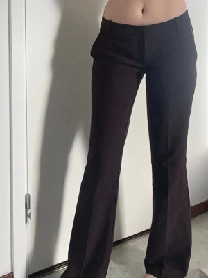 Bruna utsvängda kostymbyxor - Snygga bruna kostymbyxor med utsvängda ben och låg midja från Bik Bok. Jättebra skick då de knappt är använda. De är storlek 34. Bara skriva vid funderingar💞