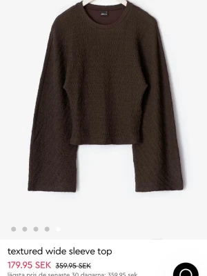 Brun topp med vida ärmar - Mörkbrun topp med textur och vida, långa ärmar. Skit snygg brun topp som inte kommer till någon användning, Den är i bra skick och har använts en gång