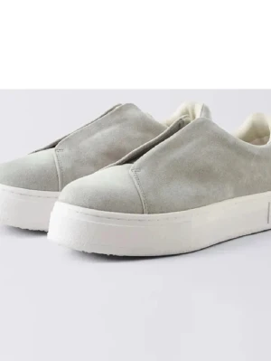 Eytys skor 38 - Nypris 2000. Stilrena sneakers i ljusgrå mocka med minimalistisk design och vit platåsula. Skorna saknar snörning för en clean look och har en mjuk ovandel i mocka som ger en exklusiv känsla. Perfekta för dig som gillar enkel och modern stil.