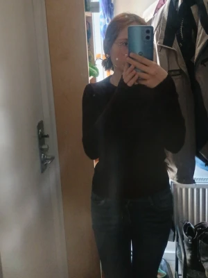 Brun  långärmad tröja basic - En enkel brun långärmad tröja med rund hals. Tröjan har en slim fit passform och är perfekt att matcha med jeans eller kjol. Materialet ser ut att vara mjukt och stretchigt, vilket gör den bekväm för vardagsbruk.