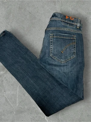 Dondup George  - Snygga mörkblå jeans från Only med slitningar på låren och knäna för en trendig look. Jeansen har klassisk femficksdesign, smal passform och är tillverkade i denim med lätt stretch. Perfekta för dig som gillar en avslappnad och cool stil.