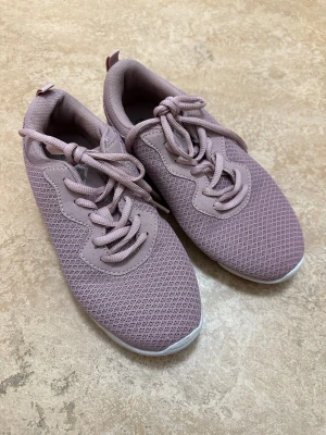 Ljusrosa mesh sneakers - Snygga ljusrosa sneakers med ovandel i mesh och matchande skosnören. Skorna har en vit, chunky sula och en sportig look. Perfekta för dig som gillar en clean och modern stil. Lätta och bekväma att bära hela dagen.