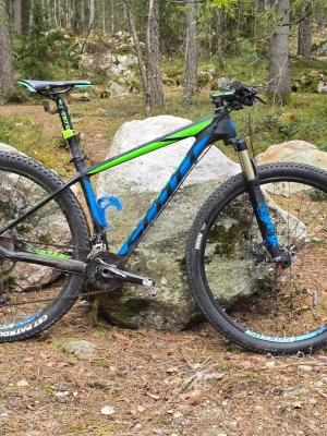 Scott scale 935 mountainbike svart/grön/blå - Nypris 23 990kr.  Scott Scale 930 mountainbike med 29-tums hjul. Cykeln har en Fox 32 Float Performance Air-gaffel med 3 lägen och 100 mm slaglängd. Utrustad med Shimano XT-växlar och hydrauliska skivbromsar. Ramen är i kolfiber.