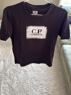 Svart C.P. Company t-shirt - Snygg svart t-shirt från C.P. Klassisk rund halsringning och korta ärmar. Tillverkad i mjuk bomull som känns skön mot huden. Perfekt för en avslappnad och trendig stil.