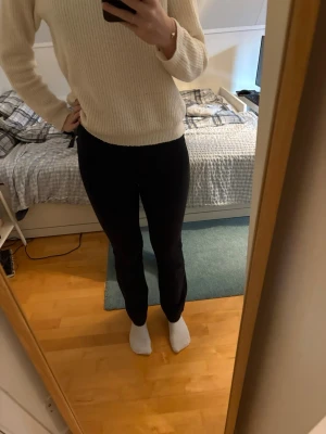 Svarta bootcut leggings - Säljer ett par svarta leggings med bootcut-modell. De är höga i midjan och har en tight passform upptill som går ut i ett lätt utsvängda ben. Perfekta till en stickad tröja eller hoodie. Materialet är stretchigt och mjukt för maximal komfort. Low waist