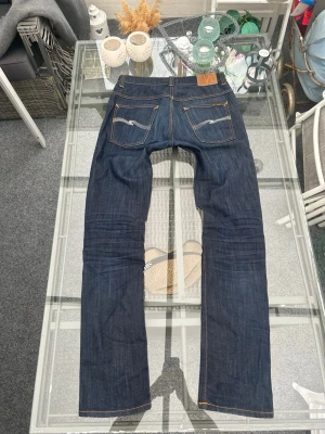 Nudie Jeans Thin Finn W33/L34 i mörk raw denim - Nudie Jeans Thin Finn W33/L34 i mörk raw denim. Slim tapered fit med clean passform och snyggt fall över skor. Ekologisk bomull med lite stretch, sköna och håller formen bra. Fint skick med naturliga fades/veck för äkta dry denim-look 🔥 Perfekta till streetwear, vintage och minimalist fits. Skickas snabbt 📦