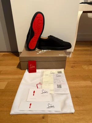 Svarta Christian Louboutin sneakers - Snygga svarta sneakers från Christian Louboutin med den ikoniska röda sulan. 