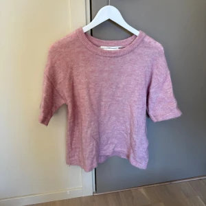 Ljusrosa stickad tröja kort ärm - Mysig ljusrosa stickad tröja med korta ärmar och rund hals. Köpt här på Plick och använd men har fortfarande bra kvalité osv 🥰 säg till om ni vill ha bilder på också☺️Storlek L men skulle mer säga att det är en oversized S!