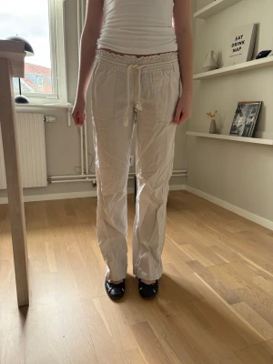 Beiga linnebyxor med dragsko - Säljer ett par beiga linnebyxor med rak passform och elastisk midja med dragsko. Byxorna har fickor både fram och bak, och är tillverkade i ett lätt och luftigt linnetyg. 