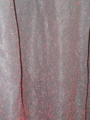 Svart glittrig klänning Elitzia - Säljer en svart klänning från Elitzia med glittrigt rött skimmer i tyget. Klänningen har en enkel, rak form och är perfekt för dig som vill sticka ut med lite extra glitter. Materialet känns mjukt och stretchigt, vilket gör den bekväm att bära.