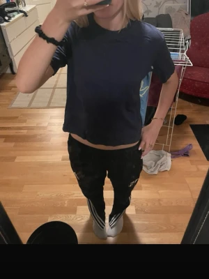 Mörkblå t-shirt - En enkel och stilren mörkblå t-shirt med rund hals och korta ärmar. T-shirten har en loose passform och är tillverkad i mjuk bomull, perfekt för en avslappnad look.