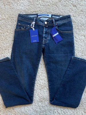 Mörkblå jeans från Jacob Cohën - Snygga sprillans nya mörkblå jeans från Jacob Cohën i modell nick storlek 31 Måtten längd:105 midja:81cm med klassisk femficksmodell. Tillverkade i mjuk och stretchig denim för extra komfort.     Självklart äkta som ni ser.     Skriv om ni har minsta fundering!!    Skickar samma dag eller dagen efter📦✅