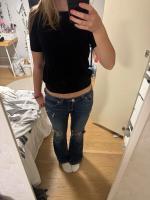 Svart kortärmad topp - Säljer en enkel och stilren svart kortärmad topp. Perfekt för vardagsbruk eller att klä upp med accessoarer. Toppen har en normal passform och är gjord i ett mjukt och bekvämt material.