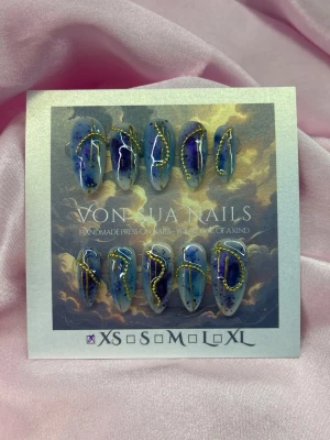 AuroraInk (XS);Medium Almond - Handgjorda press-on naglar i blå och lila nyanser med abstrakta mönster och skimrande gulddekor. Naglarna har en medium längd, almond form och är i XS: 14 mm, 11 mm, 11,5 mm, 10 mm, 8 mm . Perfekt för dig som vill ha en unik och konstnärlig look.