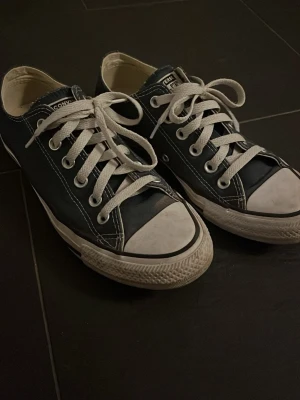 Converse låga sneakers marinblå - Låga Converse sneakers i marinblå med vita sulor och tår. Inga defekter och endast använda några fåtal gånger. Damstorlek, 38.