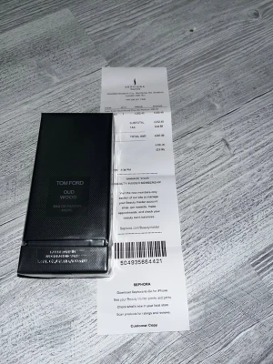 Tom Ford Oud Wood Eau de Parfum 100 ml  - Tom Ford Oud Wood Eau de Parfum i en elegant svart rektangulär flaska med diskret mönster. Flaskan rymmer 100 ml och har en lyxig känsla med minimalistisk design. Doften är känd för sina träiga och orientaliska noter, perfekt för dig som gillar exklusiva parfymer. Säljer pågrund av att min farfar köpte fel parfym i Storbritannien, Kom DM om du har mer frågor 