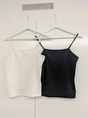 Svart och vit linnetopp från Kappahl - Två stilrena linnetoppar från Kappahl i svart och vitt. Båda har tunna axelband och ärmlös design, perfekta för varma dagar. Tillverkade i mjukt bomullsmaterial som känns skönt mot huden. Enkel och clean look som funkar till det mesta.          Nypris: 200 kr för båda.                                                    Jag säljer dem för 40 kr/st eller 70 kr för båda.