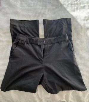 Gråa kostymbyxor  - Mörkgråa högmidjade kostymbyxor. Har sytt upp de (därav lite ojämna ner till). Jag är 157 cm. Bra skick annars.
