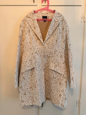 Vit spetskappa från Boohoo - Säljer en elegant vit kappa från Boohoo med vackert spetsmönster över hela plagget. Använt endast 1 gång 