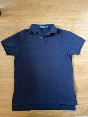 Ralph Lauren Piké - Helt vanlig klassisk piké från Ralph Lauren i marinblå färg. Skick 9/10 inga som helst defekter. Storlek M, med en custom fit, men sitter mer som slim. Hör av dig vid frågor! Öppen för att diskutera priset!