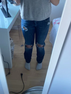 Jeans med hål.  - Raka jeans med hål. Inte lågmidjade men inte högmidjade❣️en av hålen man stoppat in skärp mm har gått upp. skriv för fler frågor. 