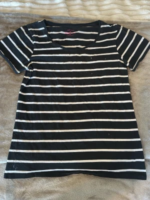 Svartvit randig t-shirt - En svart t-shirt med vita horisontella ränder. Klassisk rund halsringning och korta ärmar. Tillverkad i mjuk bomull som känns skön mot huden. Perfekt för en avslappnad och enkel stil.